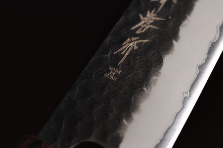 Close-up of a Japanese kitchen knife blade with engraved characters