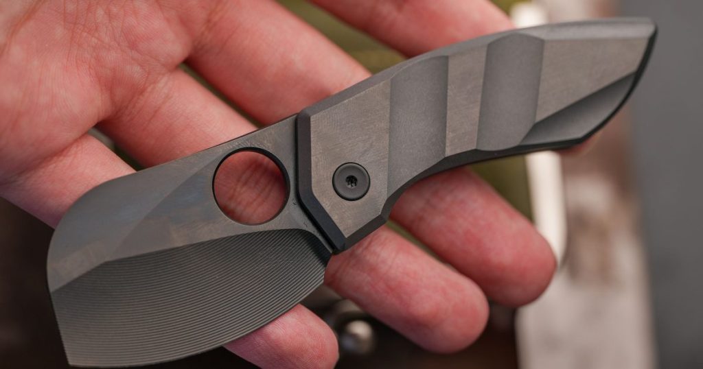 Representative compact tactical folding knife held in a hand